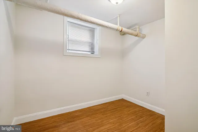 a view of a small space with wooden floor and a window
