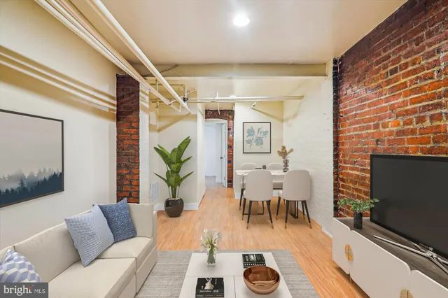 a living room with furniture a flat screen tv and a fireplace