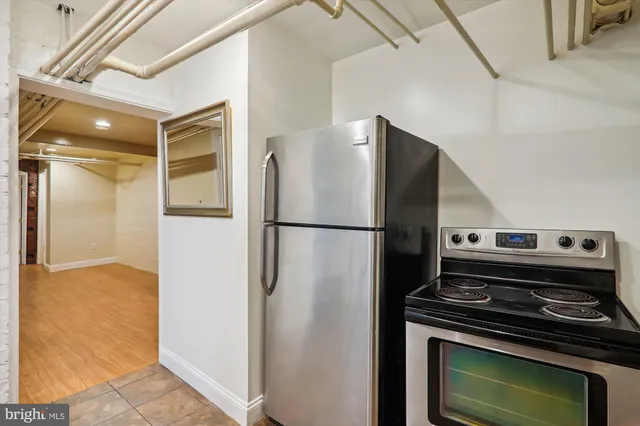 a kitchen with a refrigerator and a stove top oven