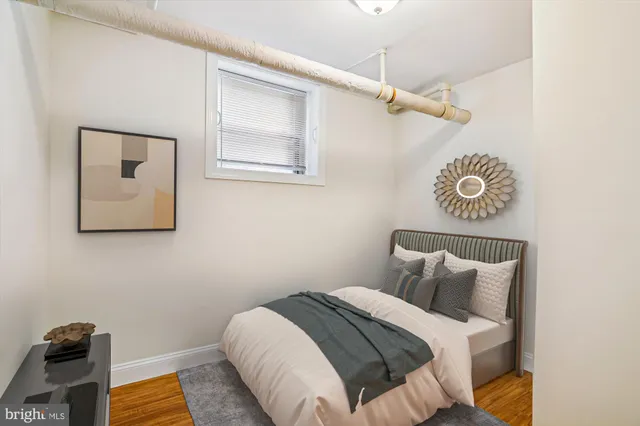 a bedroom with a bed and a lamp on the dresser