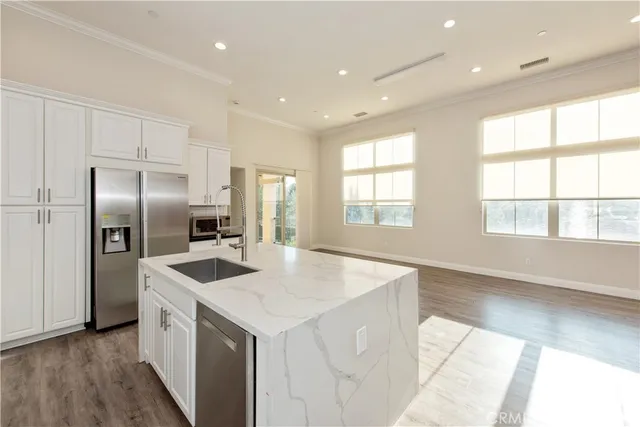 a kitchen with stainless steel appliances granite countertop a sink and a refrigerator