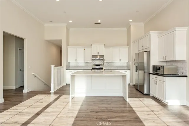 a kitchen with stainless steel appliances granite countertop a refrigerator sink and stove