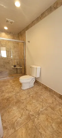 a bathroom with a toilet and a shower