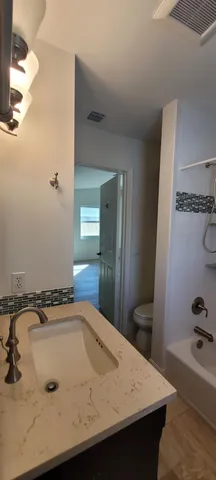 a bathroom with a tub sink and mirror