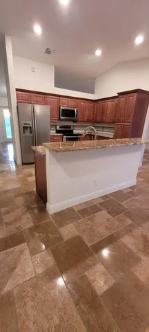 a view of kitchen with stainless steel appliances lots of counter space