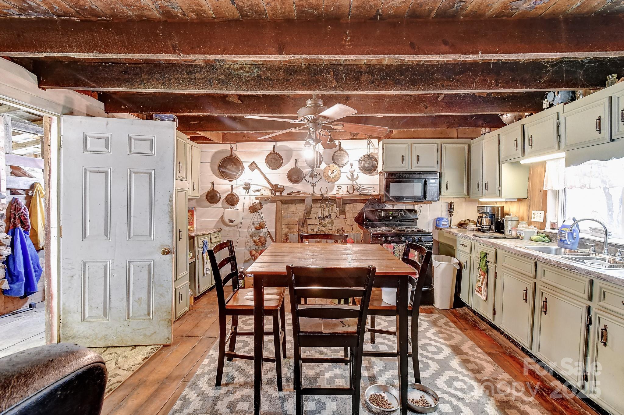 105 Home Place Road Maggie Valley, NC 28751 - Photo 2 of 24 a kitchen with stainless steel appliances a dining table chairs and wooden floor