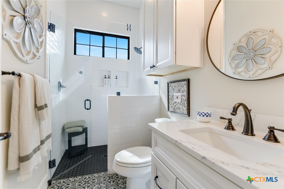 105 Retreat Place Georgetown, TX 78626 - Photo 21 of 42 a bathroom with a sink a toilet and a mirror