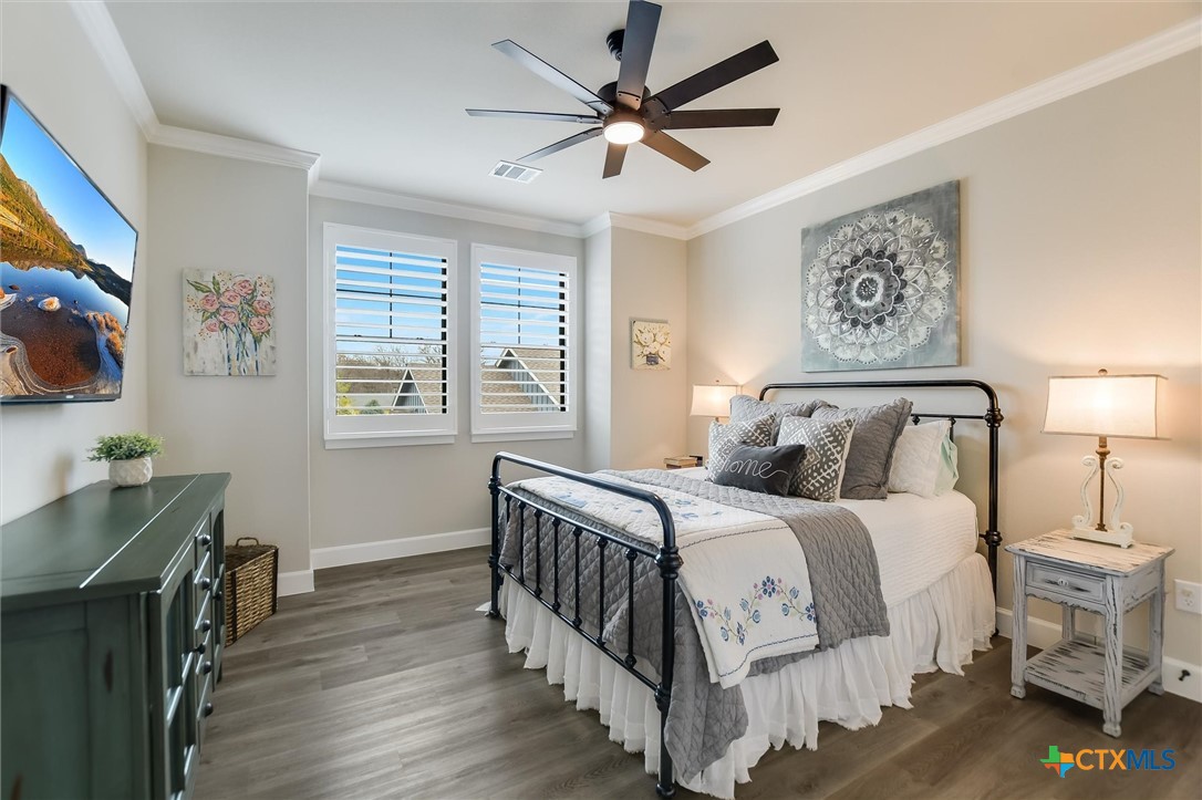 105 Retreat Place Georgetown, TX 78626 - Photo 22 of 42 a bedroom with a bed a computer on a desk and wooden floor