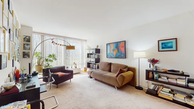 a living room with furniture a flat screen tv and a window