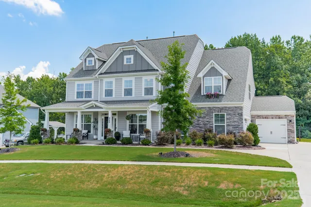 a front view of a house with a garden and trees
