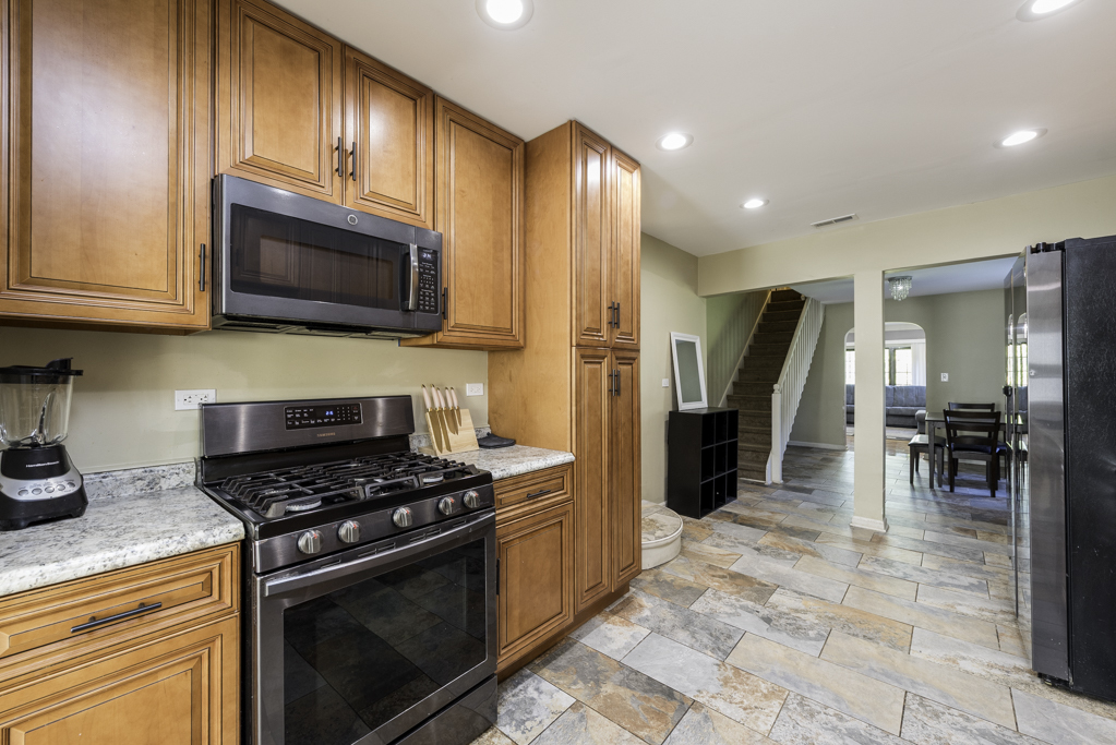 1700 Gideon Avenue Zion, IL 60099 - Photo 14 of 33 a kitchen with granite countertop a stove and a refrigerator
