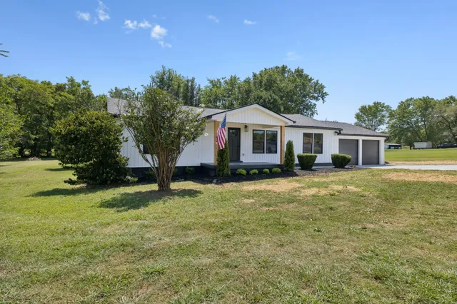 a front view of a house with yard and green space