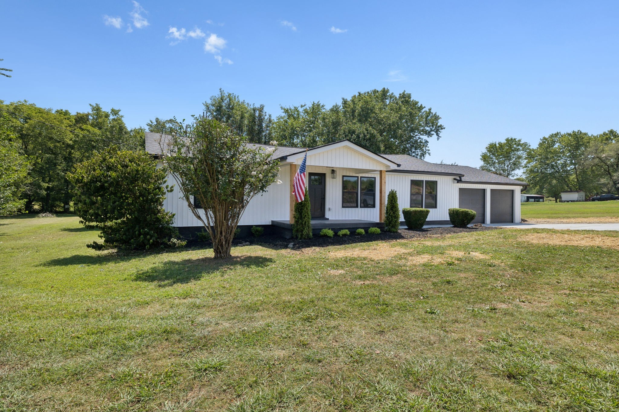 a front view of a house with yard and green space