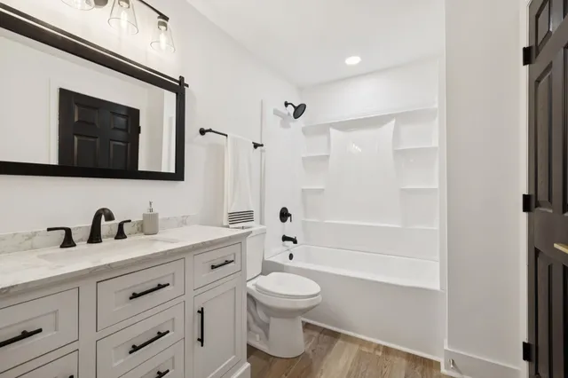 a bathroom with a toilet a sink a mirror and shower