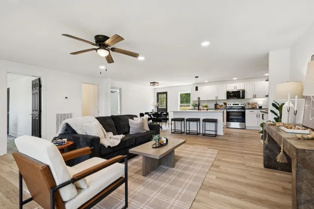 a living room with furniture and kitchen view