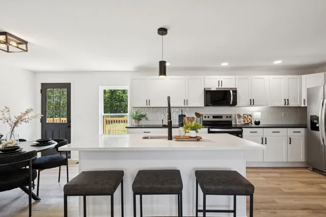 a kitchen with stainless steel appliances a stove a sink and a microwave