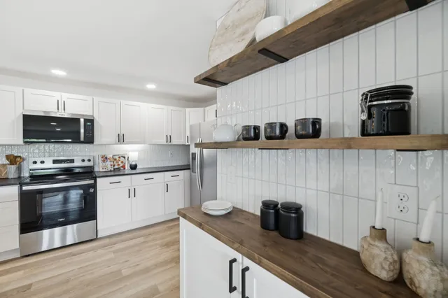 a kitchen with granite countertop a sink a stove and refrigerator
