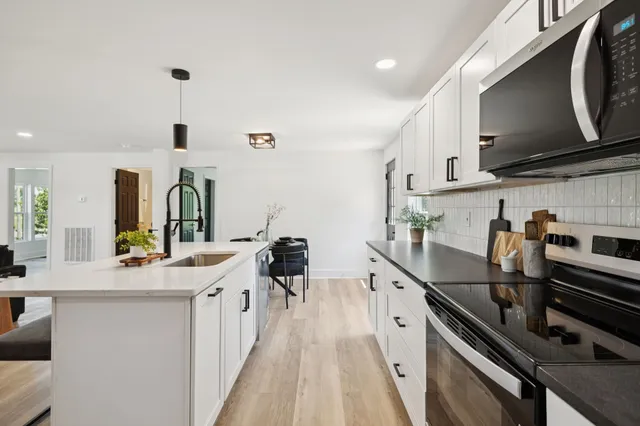 a kitchen with stainless steel appliances a sink stove and cabinets