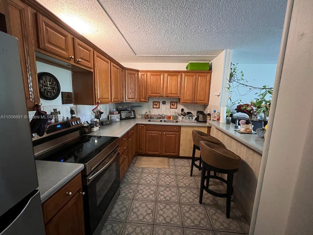 a kitchen with a sink appliances cabinets and a window