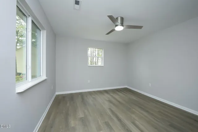 wooden floor in an empty room with a window