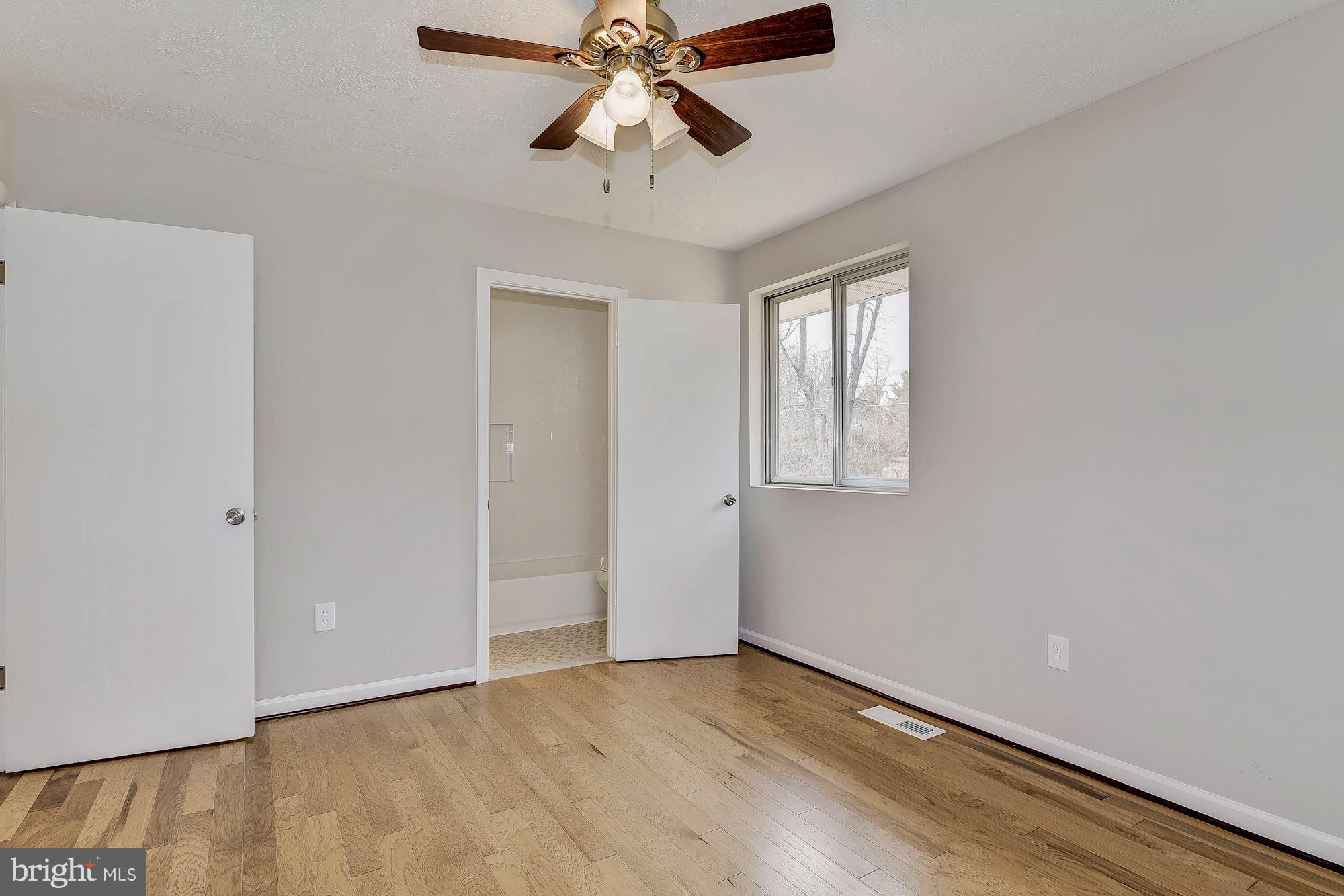 8614 Lugano Road Randallstown, MD 21133 - Photo 14 of 25 wooden floor in an empty room with a window