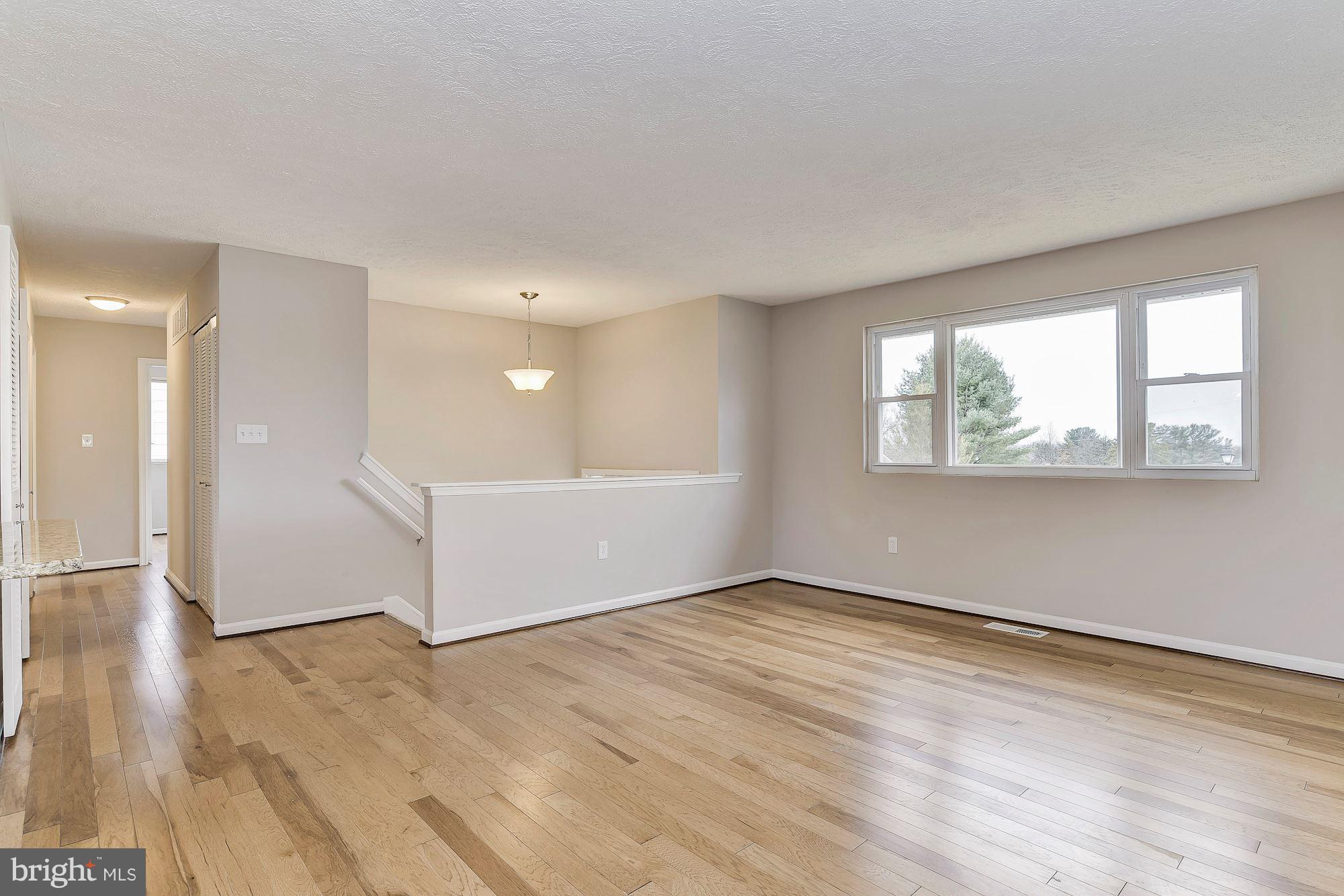 8614 Lugano Road Randallstown, MD 21133 - Photo 3 of 25 a view of an empty room with wooden floor and a window