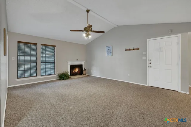 a view of empty room with a fireplace and fan