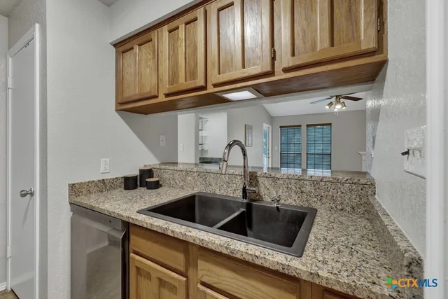 a kitchen with granite countertop a sink and a stove