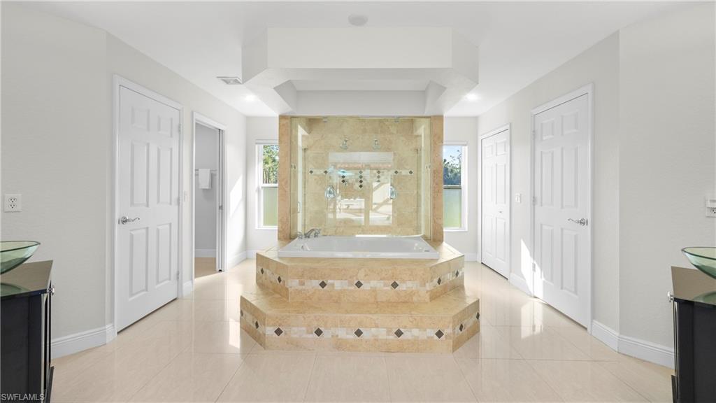 1580 16th Street Northeast Naples, FL 34120 - Photo 19 of 50 a spacious bedroom with a bed and a window