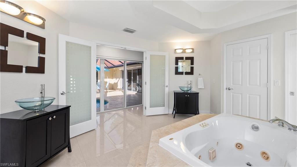 1580 16th Street Northeast Naples, FL 34120 - Photo 21 of 50 a bathroom with a tub a sink and mirror