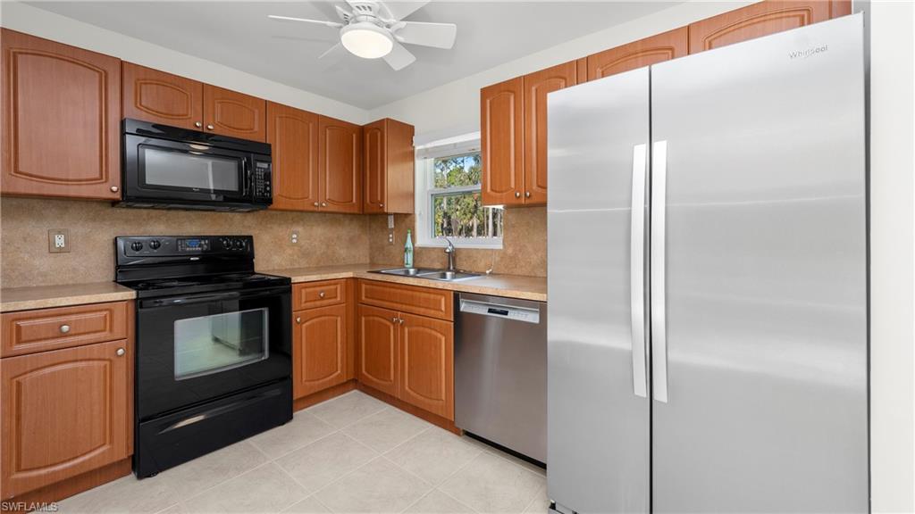 1580 16th Street Northeast Naples, FL 34120 - Photo 41 of 50 a kitchen with stainless steel appliances granite countertop a refrigerator a stove a sink and a microwave