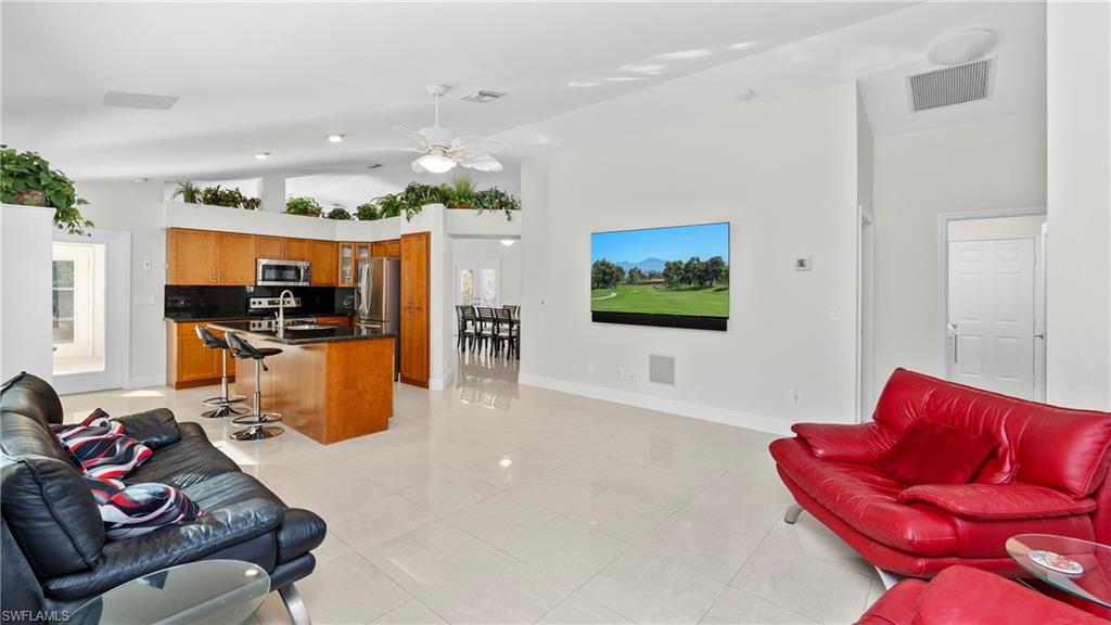 1580 16th Street Northeast Naples, FL 34120 - Photo 7 of 50 a living room with furniture kitchen view and a wooden floor