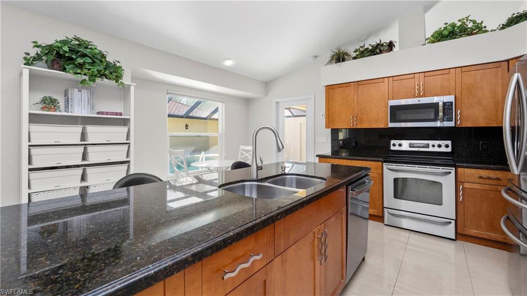 1580 16th Street Northeast Naples, FL 34120 - Photo 10 of 50 a kitchen with stainless steel appliances granite countertop a sink stove and microwave