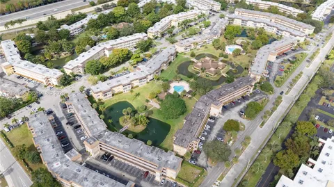 aerial view of a multi story residential apartment building with a yard