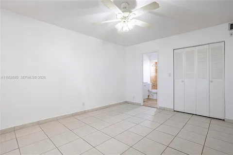 an empty room with chandelier fan