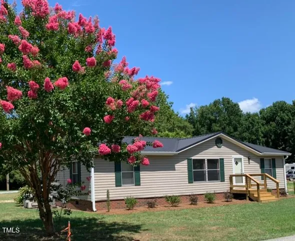 a front view of a house with a yard and fountain