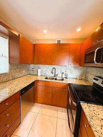a kitchen with stainless steel appliances granite countertop a sink and cabinets