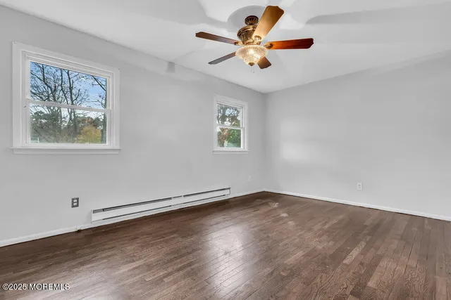 a view of an empty room with a window and a ceiling fan