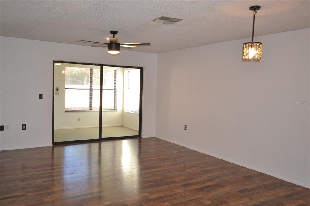 7331 Greystone Drive Hudson, FL 34667 - Photo 19 of 39 a view of empty room with wooden floor and fan