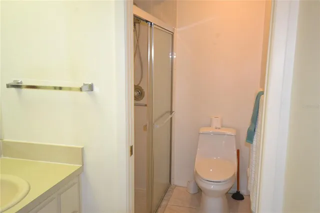 a bathroom with a granite countertop toilet and a sink