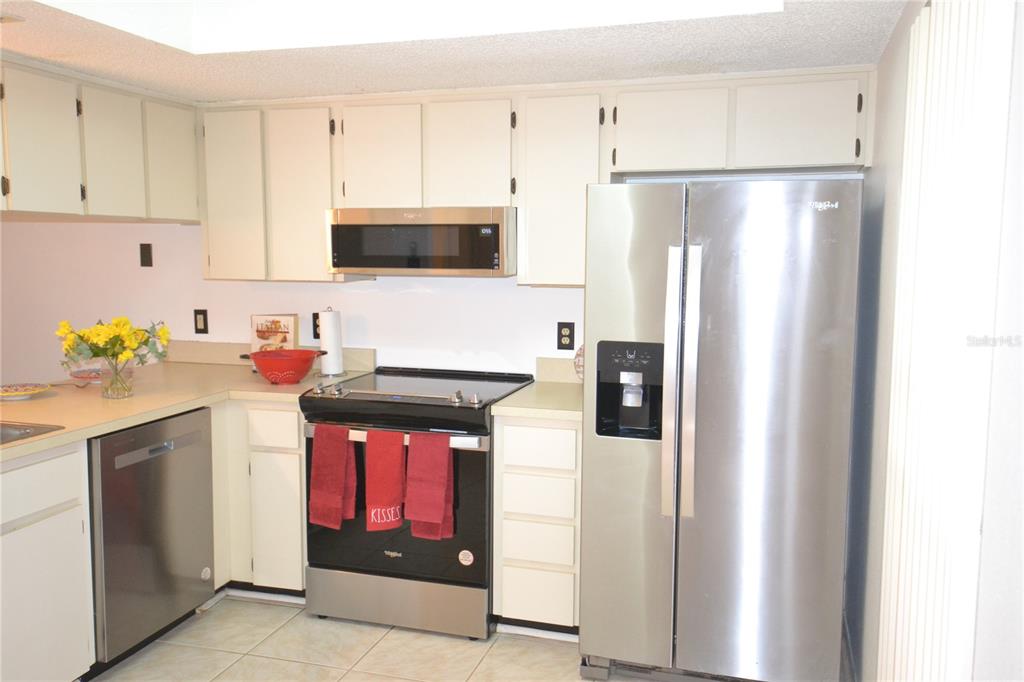 7331 Greystone Drive Hudson, FL 34667 - Photo 3 of 39 a kitchen with stainless steel appliances granite countertop a refrigerator a stove a microwave oven with white cabinets