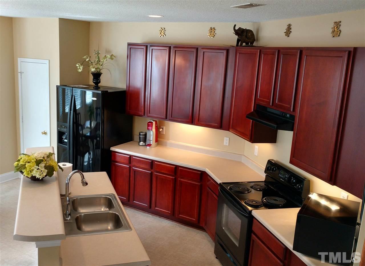 3812 Tryon Ridge Drive Raleigh, NC 27610 - Photo 7 of 23 a kitchen with wooden cabinets and a stove top oven