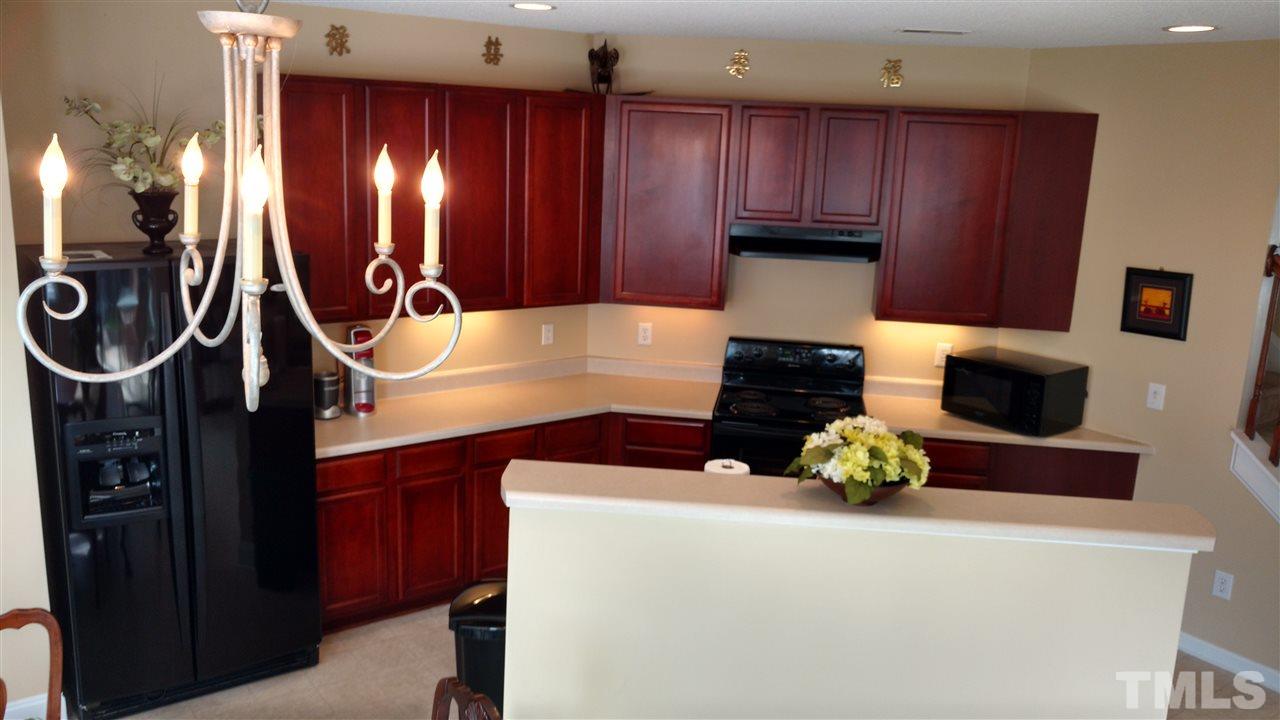 3812 Tryon Ridge Drive Raleigh, NC 27610 - Photo 9 of 23 a kitchen with wooden cabinets and a stove top oven