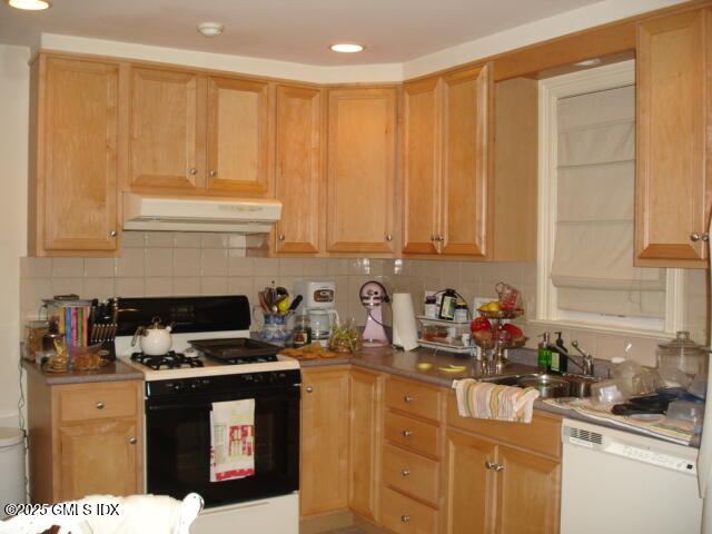 a kitchen with stainless steel appliances a stove a sink cabinets and a window