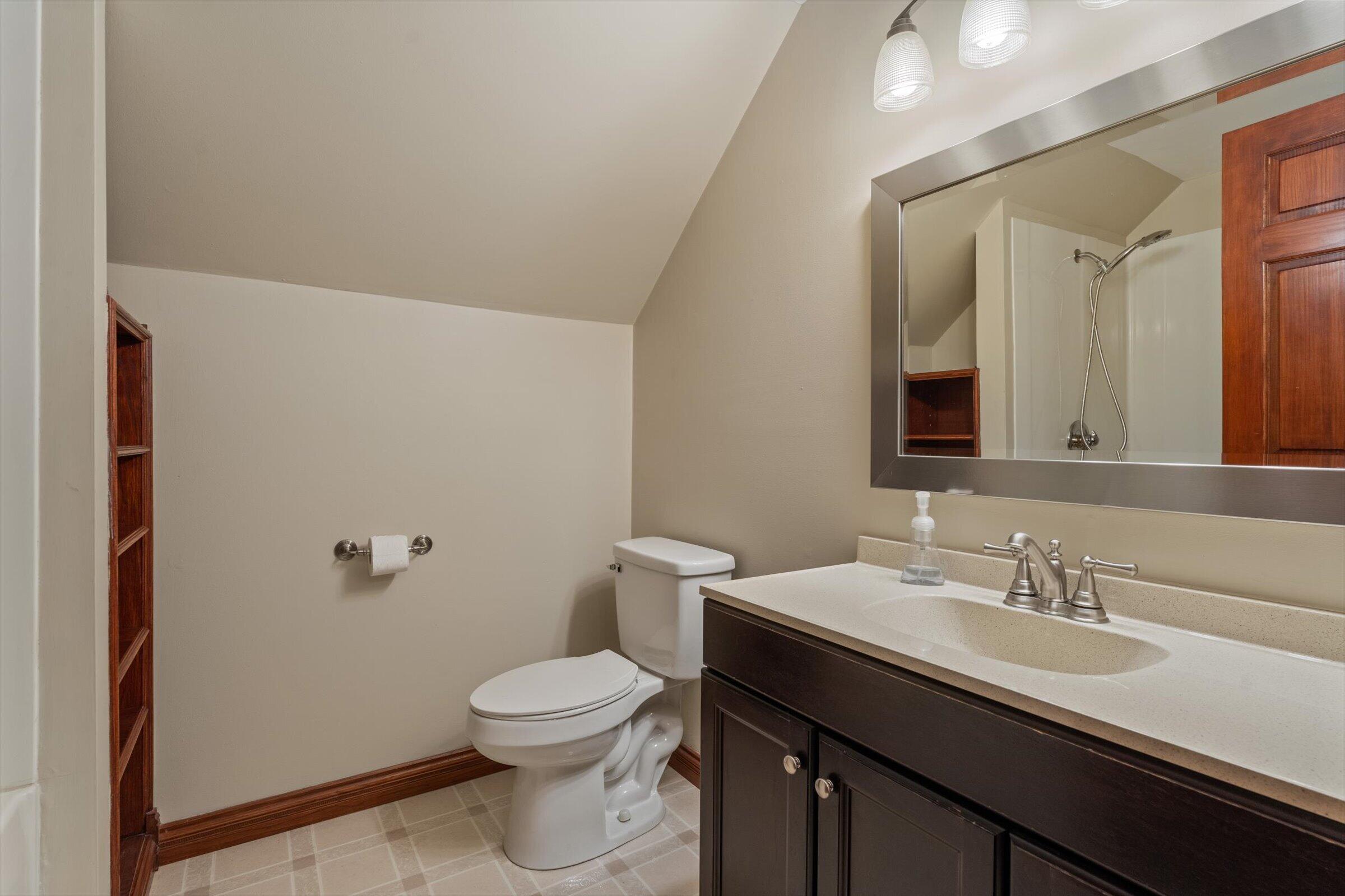 7692 North Emery Road Rolling Prairie, IN 46371 - Photo 42 of 69 a bathroom with a granite countertop sink a toilet and a mirror