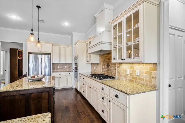 a kitchen with a stove a refrigerator and wooden floor