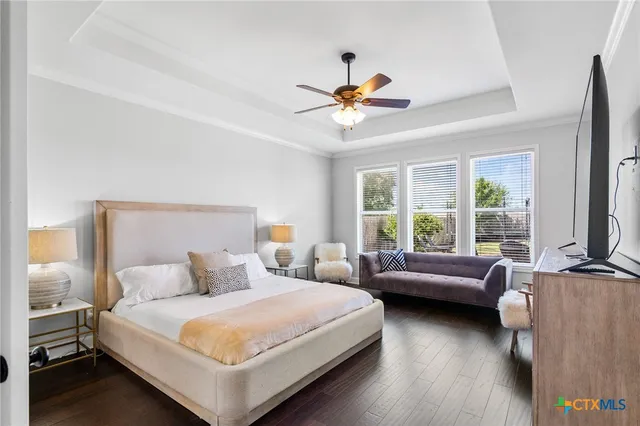 a bedroom with a bed chandelier and a window