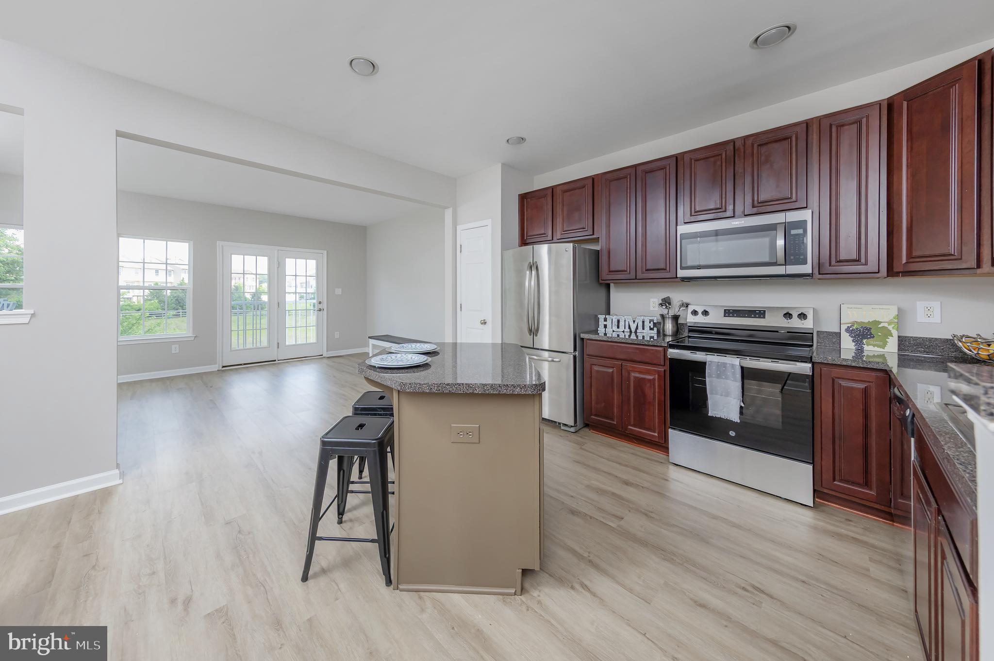 371 Concetta Drive Mount Royal, NJ 08061 - Photo 12 of 20 a kitchen with kitchen island wooden floors wooden cabinets and stainless steel appliances