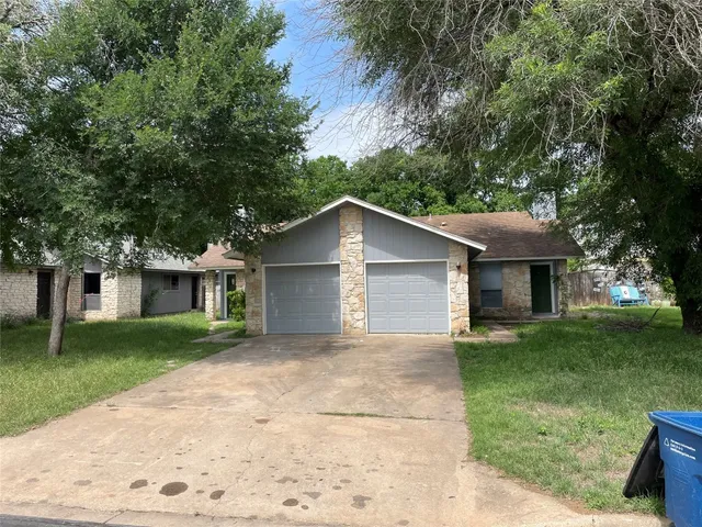 front view of a house with a yard and trees