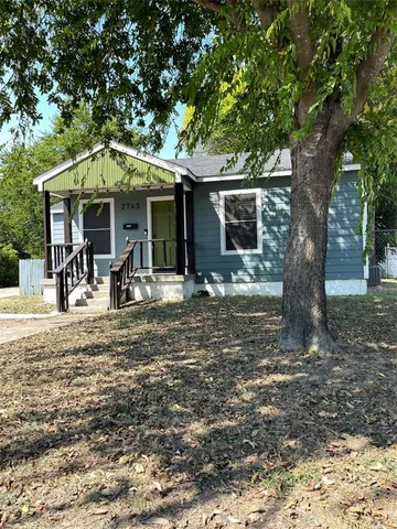 a view of a house with a large tree